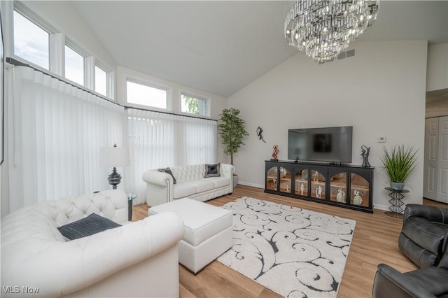 117 Nicklaus Dr NE, Warren, OH 44484 - living room featuring a chandelier, high vaulted ceiling, and wood finished floors