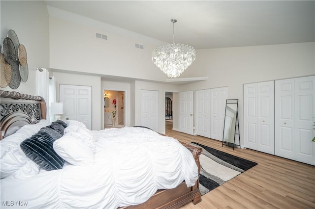 117 Nicklaus Dr NE, Warren, OH 44484 - bedroom with a chandelier, wood finished floors, a high ceiling, multiple closets, and ensuite bath