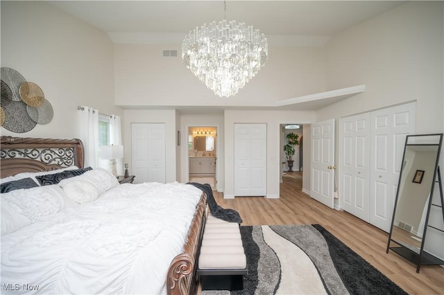 117 Nicklaus Dr NE, Warren, OH 44484 - bedroom featuring a chandelier, multiple closets, high vaulted ceiling, light wood finished floors, and ensuite bathroom