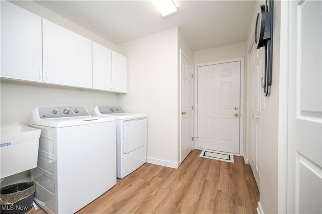 117 Nicklaus Dr NE, Warren, OH 44484 - laundry room with separate washer and dryer, light wood-type flooring, and cabinet space