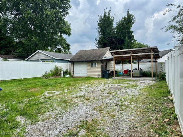 667 Eastland Ave, Akron, OH 44305 - back of property with a carport, a fenced backyard, an outbuilding, and driveway