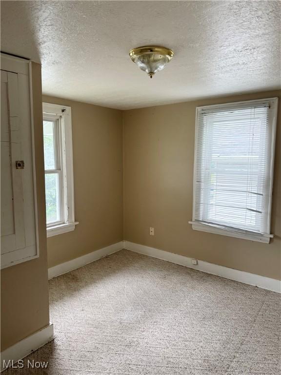 667 Eastland Ave, Akron, OH 44305 - empty room with a textured ceiling and carpet flooring