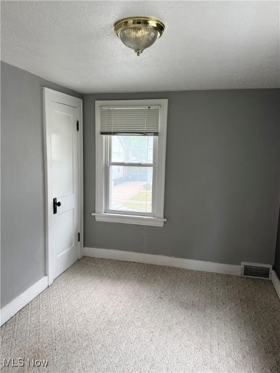 667 Eastland Ave, Akron, OH 44305 - empty room featuring light colored carpet and a textured ceiling