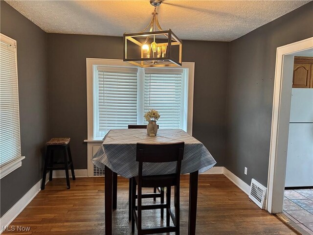 667 Eastland Ave, Akron, OH 44305 - dining room with a chandelier, a textured ceiling, and wood finished floors