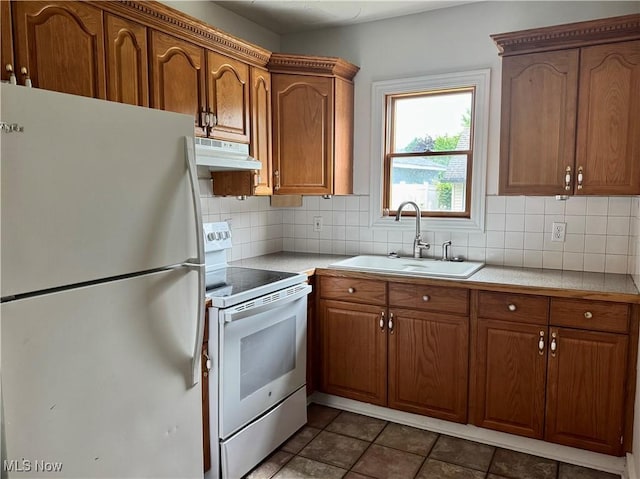 667 Eastland Ave, Akron, OH 44305 - kitchen featuring white appliances, under cabinet range hood, light countertops, tasteful backsplash, and brown cabinets