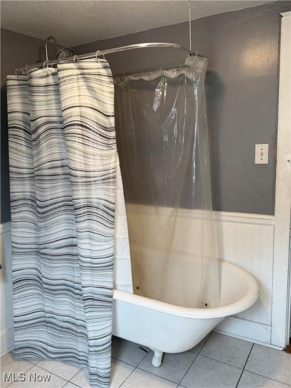 667 Eastland Ave, Akron, OH 44305 - bathroom with wainscoting, tile patterned flooring, a textured ceiling, and shower / bath combination with curtain