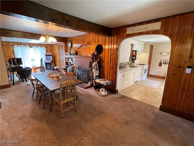 717 Calla Rd E, Poland, OH 44514 - dining space with wooden walls, arched walkways, a fireplace, light carpet, and beam ceiling