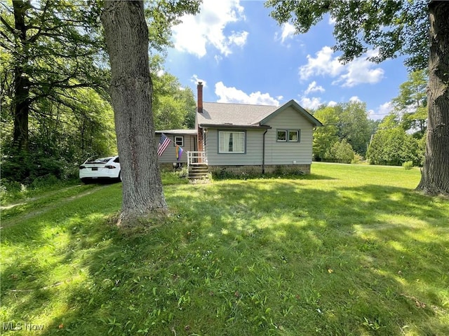 717 Calla Rd E, Poland, OH 44514 - view of home's exterior featuring a chimney and a lawn
