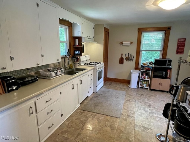 717 Calla Rd E, Poland, OH 44514 - kitchen featuring white range with gas cooktop, under cabinet range hood, stainless steel microwave, tasteful backsplash, and light countertops