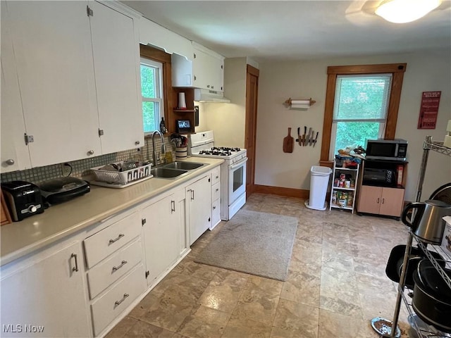 717 Calla Rd E, Poland, OH 44514 - kitchen with gas range gas stove, stainless steel microwave, under cabinet range hood, tasteful backsplash, and light countertops