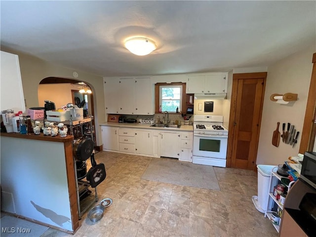 717 Calla Rd E, Poland, OH 44514 - kitchen featuring white appliances, under cabinet range hood, arched walkways, white cabinetry, and light countertops