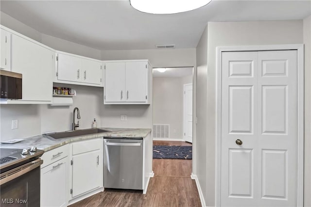 1851 King James Unit 322, Westlake, OH 44145 - kitchen featuring stainless steel appliances, dark wood-style flooring, white cabinets, and light countertops