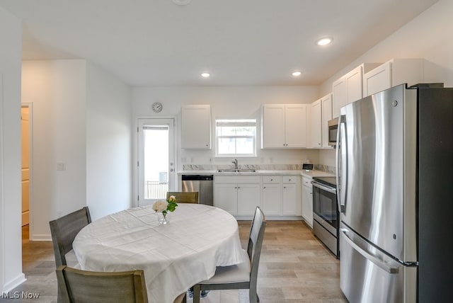 677 Crossings Ln, Akron, OH 44320 - kitchen with appliances with stainless steel finishes, white cabinetry, light countertops, light wood-style floors, and recessed lighting