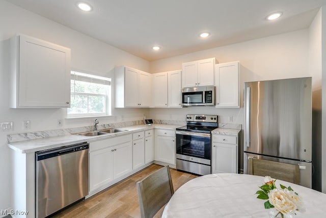 677 Crossings Ln, Akron, OH 44320 - kitchen featuring stainless steel appliances, light wood finished floors, white cabinetry, and recessed lighting