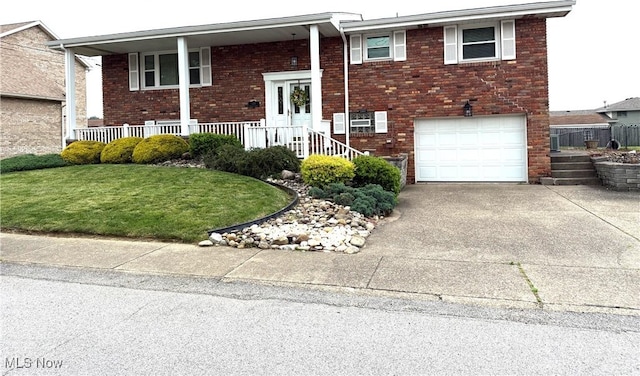 120 Kennedy Ave, Follansbee, WV 26037 - bi-level home with concrete driveway, a garage, brick siding, a front lawn, and covered porch