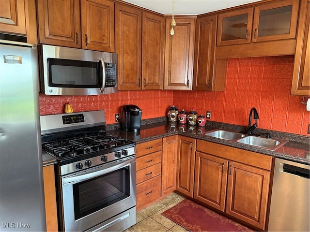 9237 Shephard Rd, Macedonia, OH 44056 - kitchen featuring appliances with stainless steel finishes, brown cabinets, decorative backsplash, light tile patterned flooring, and glass insert cabinets