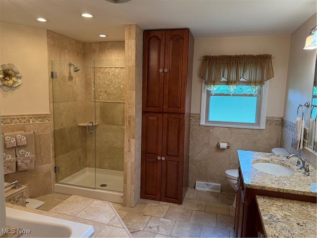 9237 Shephard Rd, Macedonia, OH 44056 - bathroom with tile walls, a shower stall, vanity, wainscoting, and recessed lighting