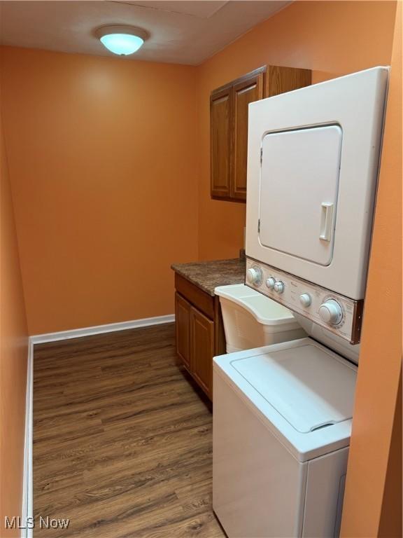 9237 Shephard Rd, Macedonia, OH 44056 - laundry room featuring cabinet space, stacked washer and clothes dryer, and wood finished floors
