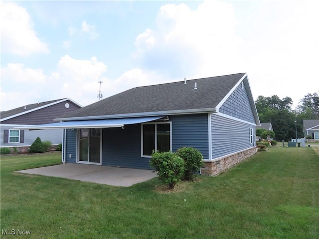 723 Whisper Creek Ln, Lodi, OH 44254 - back of property with a patio area, a yard, a shingled roof, and stone siding