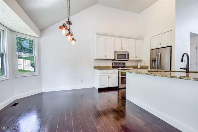 9798 Firestone Ln, Macedonia, OH 44056 - kitchen featuring appliances with stainless steel finishes, light stone countertops, white cabinets, decorative light fixtures, and dark wood-style flooring