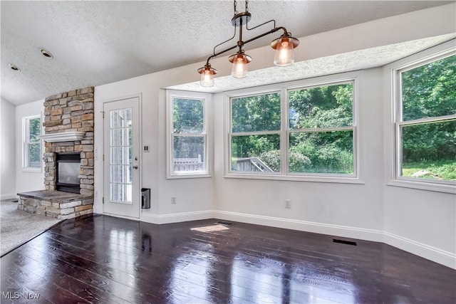 9798 Firestone Ln, Macedonia, OH 44056 - unfurnished dining area with healthy amount of natural light, a textured ceiling, wood-type flooring, and a stone fireplace