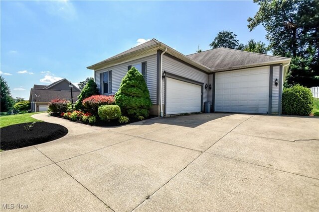 9798 Firestone Ln, Macedonia, OH 44056 - view of side of home with an attached garage and driveway