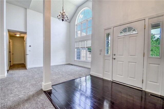 9798 Firestone Ln, Macedonia, OH 44056 - foyer entrance featuring healthy amount of natural light, dark wood finished floors, a chandelier, dark carpet, and high vaulted ceiling