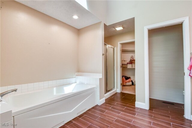9798 Firestone Ln, Macedonia, OH 44056 - full bath with a garden tub, a shower stall, wood tiled floors, and a walk in closet