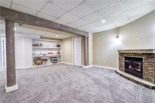 9798 Firestone Ln, Macedonia, OH 44056 - unfurnished living room with carpet flooring, a glass covered fireplace, built in shelves, a drop ceiling, and ornate columns