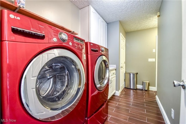 9798 Firestone Ln, Macedonia, OH 44056 - laundry area with washer and clothes dryer, a textured ceiling, cabinet space, and dark wood-style floors