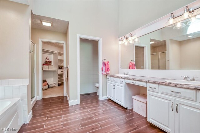 9798 Firestone Ln, Macedonia, OH 44056 - bathroom with double vanity, a stall shower, wood finished floors, and a bath