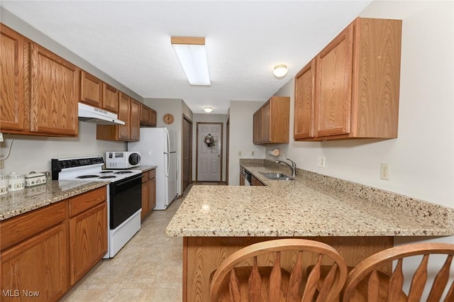 1412 Tewksbury Cir Unit 1C, Cuyahoga Falls, OH 44221 - kitchen with white appliances, under cabinet range hood, a peninsula, and light stone countertops