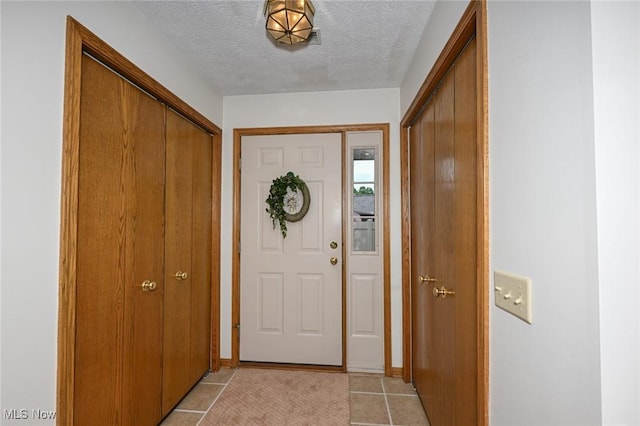 1412 Tewksbury Cir Unit 1C, Cuyahoga Falls, OH 44221 - entryway featuring a textured ceiling and light tile patterned flooring