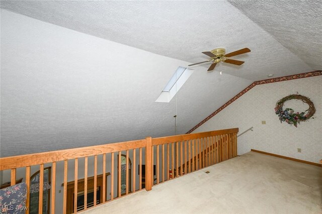 1412 Tewksbury Cir Unit 1C, Cuyahoga Falls, OH 44221 - corridor featuring a skylight, vaulted ceiling, carpet flooring, and a textured ceiling