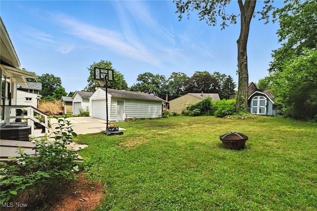 2107 13th St, Cuyahoga Falls, OH 44223 - view of green lawn with a fire pit, a garage, and a storage shed