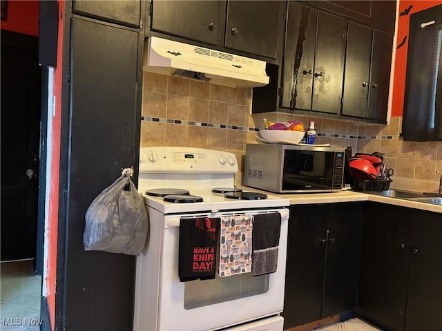 748 Belleview Rd, Cambridge, OH 43725 - kitchen with electric range, stainless steel microwave, under cabinet range hood, tasteful backsplash, and light countertops