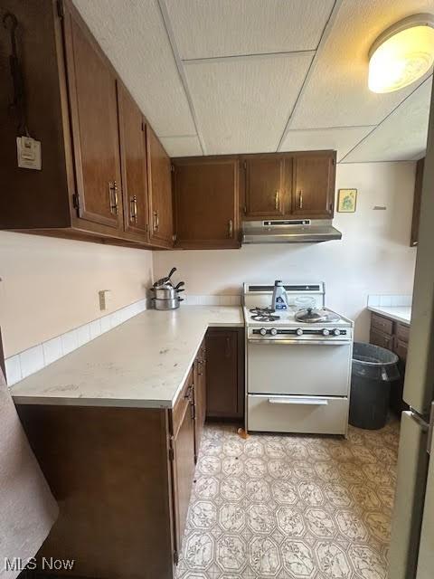 195 Water St, Wadsworth, OH 44281 - kitchen featuring white range with gas stovetop, under cabinet range hood, light countertops, and a paneled ceiling