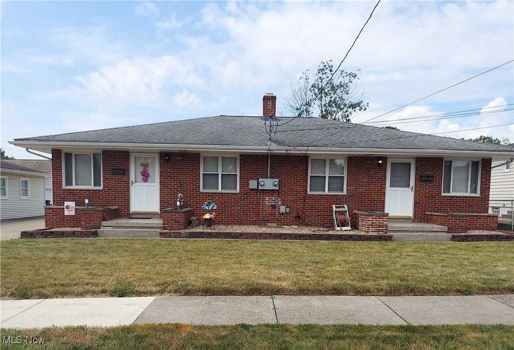 594-596 Hillman Rd, Akron, OH 44312 - view of front of house with brick siding, a chimney, a front lawn, and a shingled roof