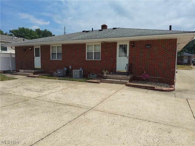 594-596 Hillman Rd, Akron, OH 44312 - back of house featuring brick siding, roof with shingles, and a chimney