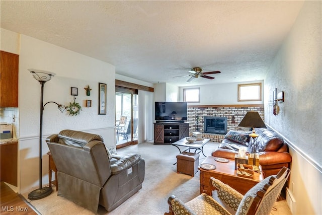 10154 Carlswood Ave NE, Hartville, OH 44632 - living room featuring ceiling fan, a textured ceiling, and a fireplace