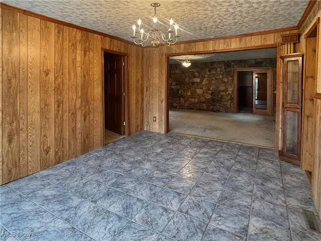507 Harker Ave, Newell, WV 26050 - spare room with a chandelier, wooden walls, and ornamental molding