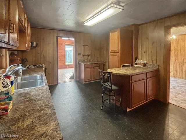 507 Harker Ave, Newell, WV 26050 - kitchen featuring wood walls, brown cabinets, and dark flooring