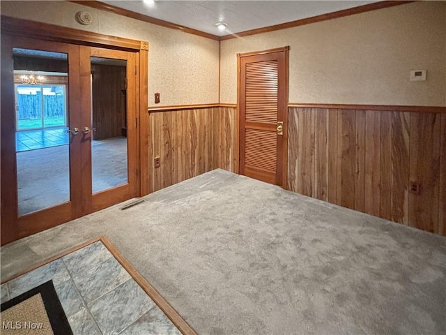 507 Harker Ave, Newell, WV 26050 - empty room with ornamental molding, wood walls, wainscoting, and french doors
