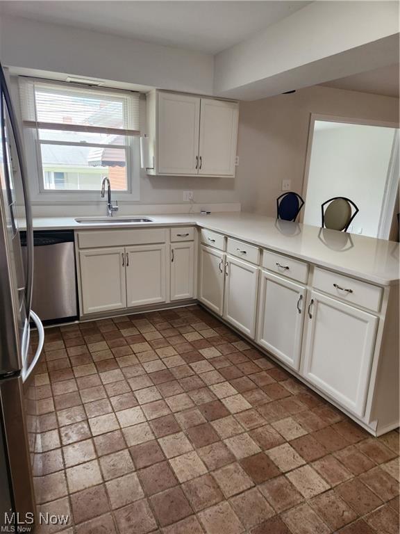 16805 Scottsdale Blvd, Shaker Heights, OH 44120 - kitchen with stainless steel appliances, white cabinets, light countertops, and a peninsula