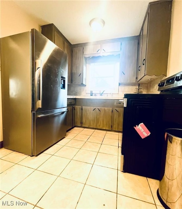 617 Valley St, Minerva, OH 44657 - kitchen with stainless steel fridge, light tile patterned flooring, decorative backsplash, and light countertops