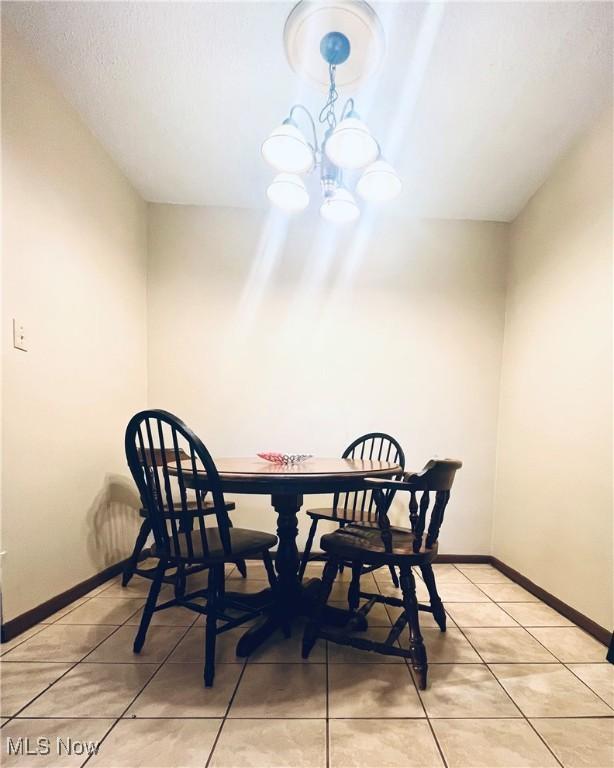 617 Valley St, Minerva, OH 44657 - dining space featuring light tile patterned floors and a chandelier