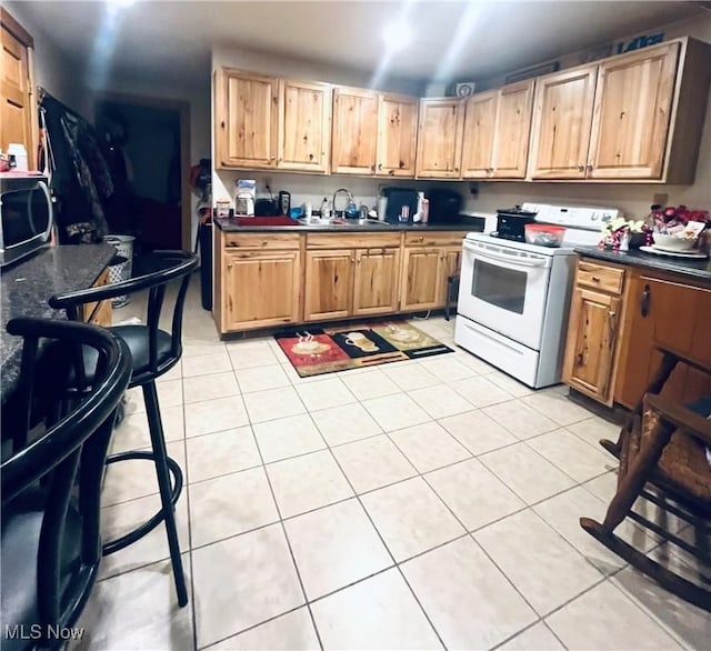 617 Valley St, Minerva, OH 44657 - kitchen with white electric stove, dark countertops, and light tile patterned flooring