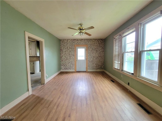 1707 23rd St, Parkersburg, WV 26101 - empty room featuring light wood-style floors, a ceiling fan, and wallpapered walls
