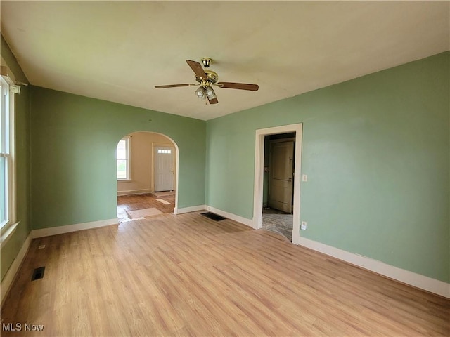 1707 23rd St, Parkersburg, WV 26101 - empty room with arched walkways, ceiling fan, and light wood-style floors