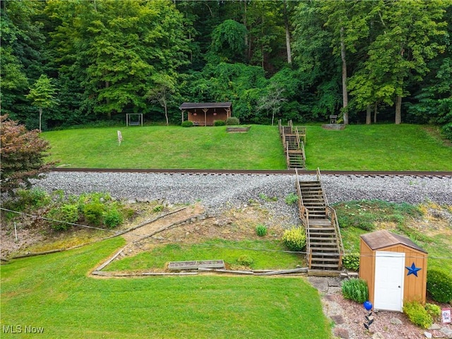 355 Muskingum River Rd, Marietta, OH 45750 - view of grassy yard featuring stairs, a storage unit, and a forest view